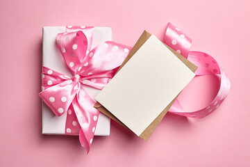 Greeting card mockup with gift box on pink background