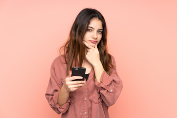 Young caucasian woman isolated on pink background thinking and sending a message