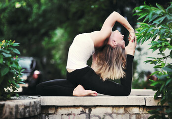 Young blonde woman practicing yoga on a city street