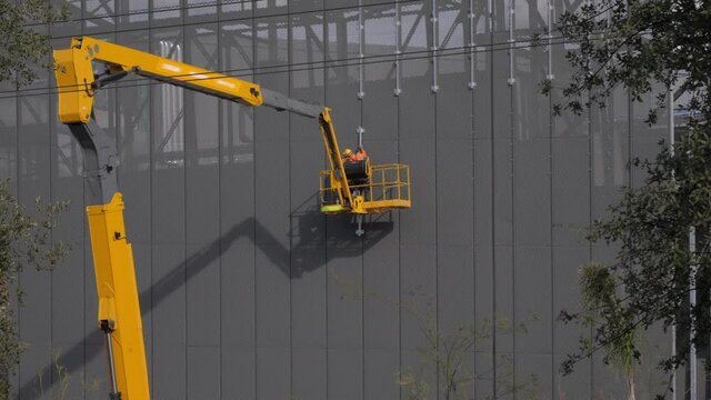 Assemblers are performing the high-altitude installation work on the telescopic boom of the lift platforms. Installation of steel beams 