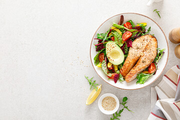 Salmon fish steak grilled, avocado and fresh vegetable salad with tomato, bell pepper and leafy...