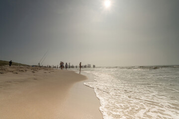 Seascape with blurred people walking in the background. Silhouette of people on the beach and in the sea. Vintage style photo. focus on foreground