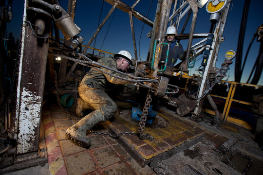 Canada, Alberta, Oil workers using oil drill