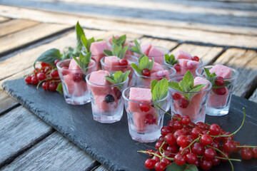 Summer time dessert decorated with berries placed on a wood plank surface.