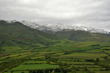Fototapeta na wymiar Valle verde y montañas blancas
