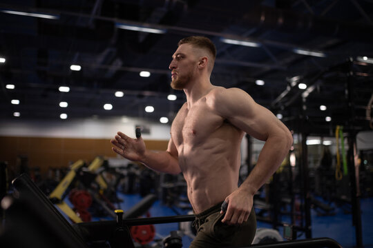Muscular athlete running on treadmill