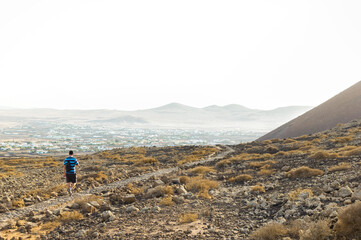 Man hiking through mountainous and desert landscape of Fuerteventura
