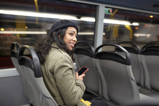 Smiling woman sitting in a public bus at night