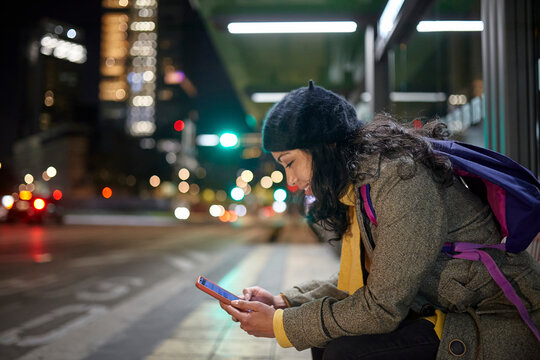 smiling woman sitting in the bus station at night