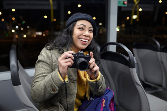 smiling woman taking photos in a public transportation