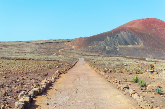 Desert and mountainous patch in arid landscape on sunny day. Way to Calder&oacute;n Hondo volcano in Fuerteventura.