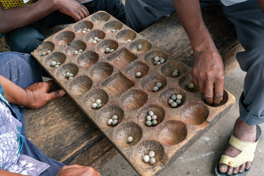 Hands of Black African People playing Mancala game, Dar Es Salaam, Tanzania. Mancala or Bao is a game which is very popular in Africa and Arabs