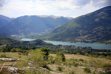 Fototapeta na wymiar Barrea lake set in the mountains covered with vegetation, Barrea, Abruzzo National Park, Italy