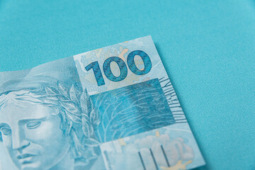 One hundred reais note on light blue background