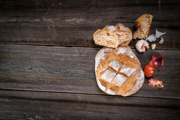 Country bread, garlic cloves and french dry shallots on a barn wood board
