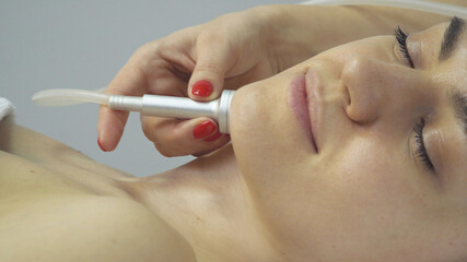 Face of woman having oxygen facial treatment in beauty salon