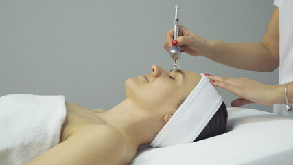 Face of woman having oxygen facial treatment in beauty salon