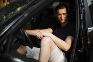 Fototapeta na wymiar Young man sitting in his car.