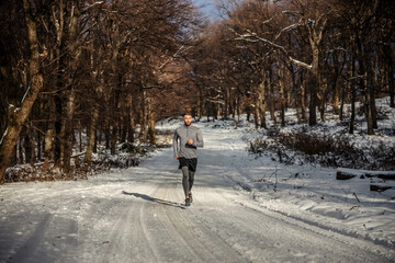 Sportsman running in nature on snow at winter. Winter fitness, fitness in nature, chilly weather