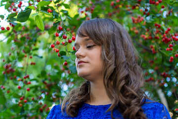 Portait of cute teen girl with makeup posing in cherry garden