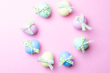 Easter holiday. Colourful egg with tape ribbon on pastel pink background in Happy Easter decoration. Spring holiday top view with copy space.