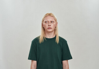 Calm young caucasian blond man in dark green t-shirt