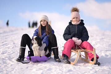 Fototapeta na wymiar Cute children and dog playing in snow
