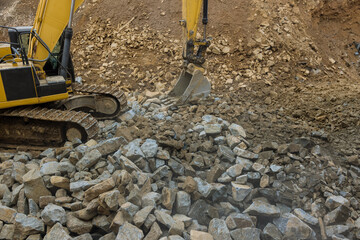 Under unfinished road construction excavator work with a stone