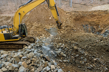 Excavator front loader with a bucket filled with crushed stone