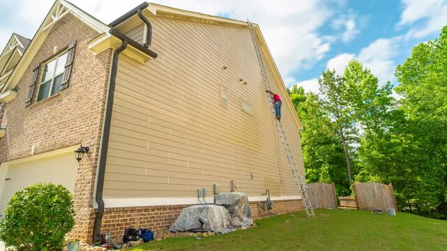 Timelapse of Workers Painting the Siding of a Home. timelapse of a worker going along side a home with a ladder painting the siding of a home