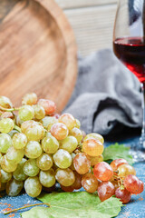 Bunch of grapes and a glass of wine on blue background