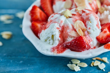 Strawberries vanilla ice-cream with sprinkles in the white plate