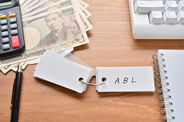 On the desk were Japanese yen bills, a keyboard, a notebook, and a word book with the word ABL written on it. It was an abbreviation for the financial term Asset Based Lending.