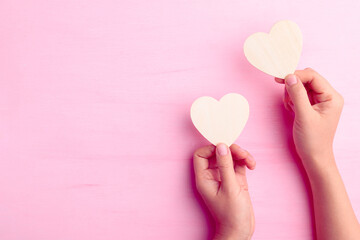 Hand holding heart shape for giving on pink background, Valentine day