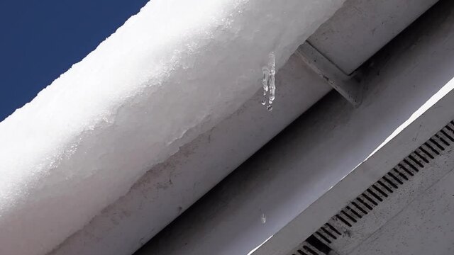 Melt water dripping from a rooftop in the early Spring