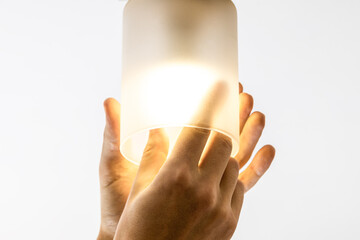 handyman replacing light bulb at wall lamp. changing light equipment for more energy efficient...