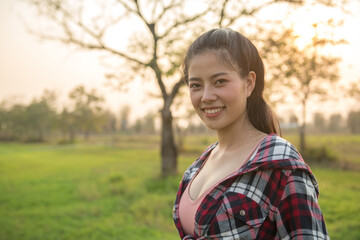 Fototapeta premium Beautiful woman in green grass at sunset