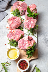 Pork Osso Buco, shin Pork shanks with fresh aromatic herbs on white marmol board