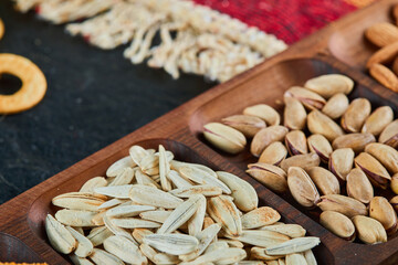 Pistachios, almonds and sunflower seeds on wooden plate