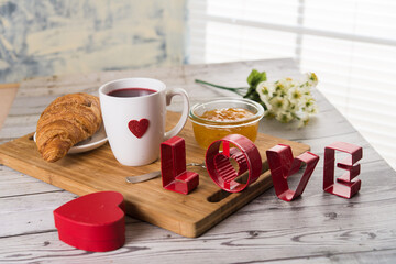 Valentine's day croissant, coffee and lheart on the table