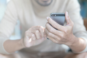 close-up hand of young man using smartphone at home, communication, connection concept