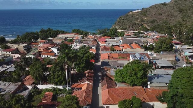 Aerial shot of Puerto Colombia town, Aragua State, Venezuela, high angle forward approach