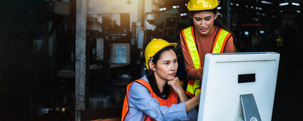 group of Asian engineer team wearing helmet and reflective vest in check and control on computer industry,