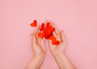 Valentine's day background Template for posters and banners Woman is holding red paper hearts in her hands Romantic photo in minimal style