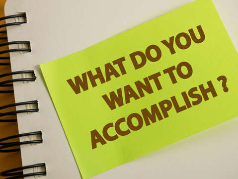 What do you want to accomplish, text words typography written on paper against wooden background, life and business motivational inspirational