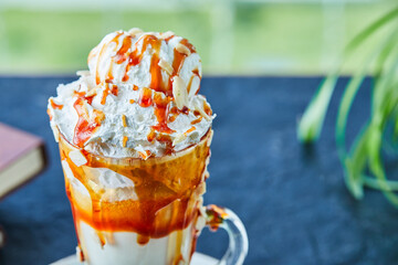 Caramel milkshake with sprinkles in the green background