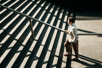 Business, ambitoins, people and lifestyle concept: Businessman climbing stairs. Summer day.