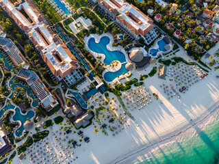 Aerial drone view of beach resort hotels with pools, umbrellas and blue water of Atlantic Ocean,...