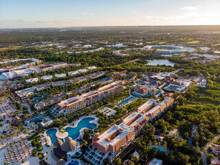 Fototapeta premium Aerial drone view of beach resort hotels with pools, umbrellas and blue water of Atlantic Ocean, Bavaro, Punta Cana, Dominican Republic