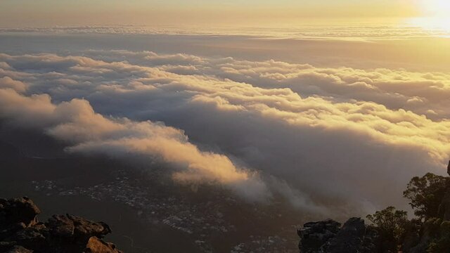 Landscape time lapse - colorful moving clouds during sunset from above on Table Mountain with bird eye view of Cape Town, Cape Town, South Africa